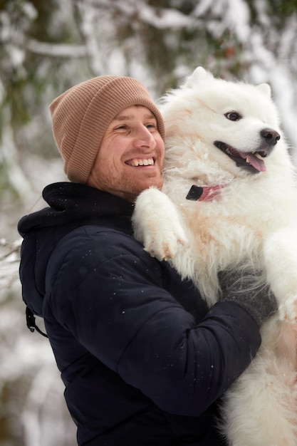 Um humano e um cachorro são melhores amigos homem e cachorro andam na floresta nevada no inverno na neve profunda em um dia ensolarado