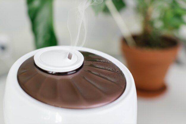 Foto um humidificador de ar branco que espalha vapor humidificação de ar seco foco seletivo no vapor