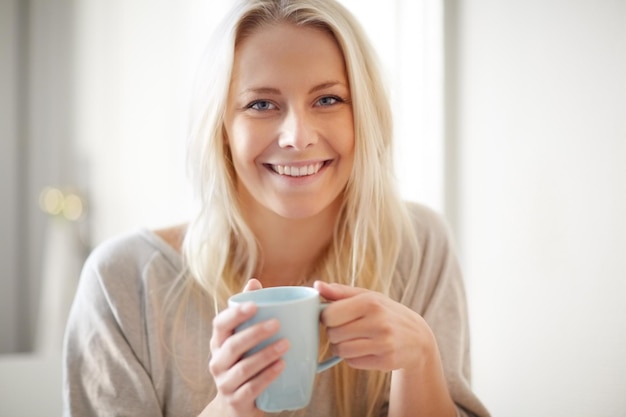 Um impulso pela manhã Uma bela jovem desfrutando de uma xícara de café pela manhã