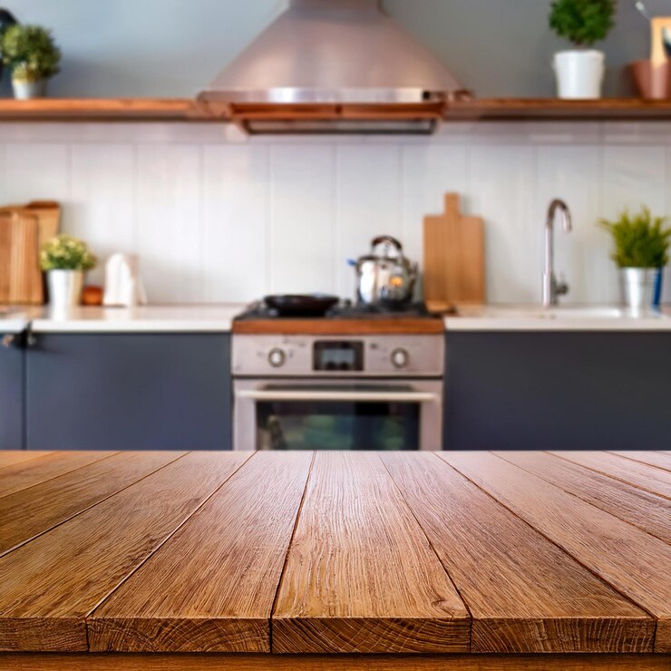 Foto um interior de cozinha com foco em uma mesa de madeira ou bancada em primeiro plano a mesa tem um natu