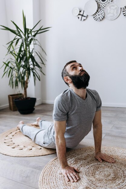 Foto um iogue masculino com barba fazendo asanas de ioga e exercícios esportivos para um corpo forte e flexível