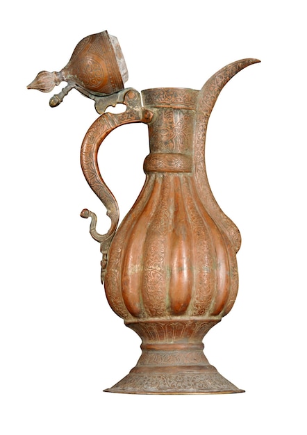 Um jarro de cobre antigo com perseguição artística e gravura em um fundo branco