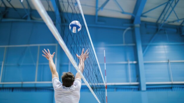 Um jogador de vôlei jogando a bola sobre a rede visando um ponto