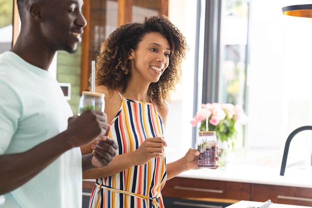 Um jovem afro-americano e uma mulher biracial desfrutam de bebidas juntos