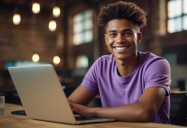 Foto um jovem alegre senta-se em uma mesa com um laptop radiando com um sorriso confiante o ambiente