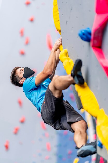 Um jovem alpinista praticando escalada em uma parede de escalada.