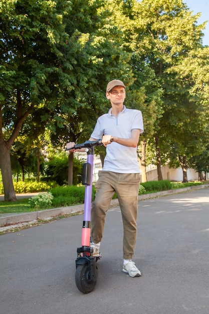 Um jovem anda em uma scooter elétrica alugada no parque