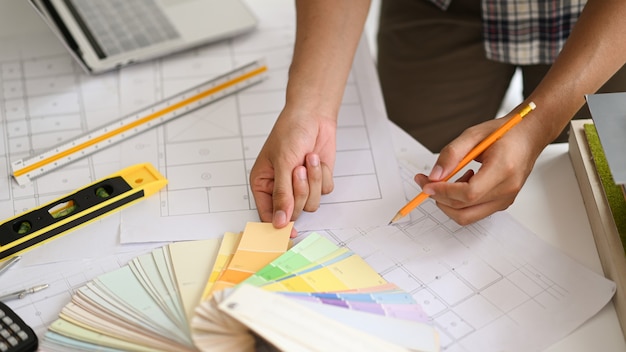 Um jovem arquiteto escolhe uma cartela de cores para o projeto da casa