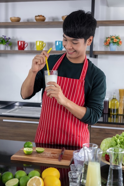 Um jovem asiático mostra limonada batido.