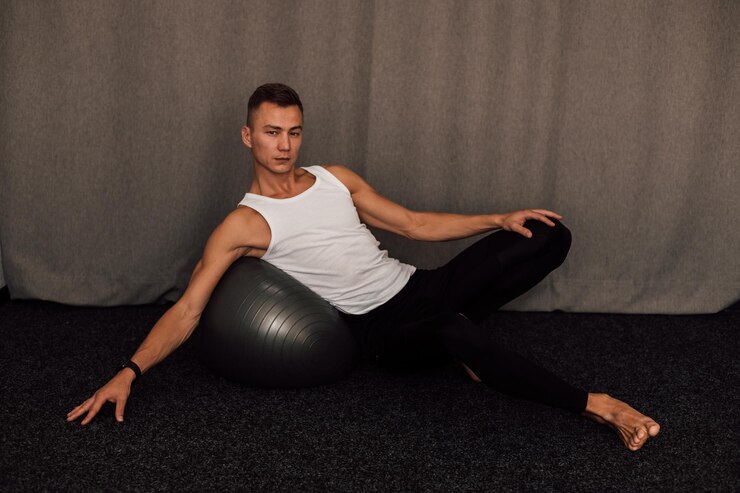 Foto um jovem atleta realiza exercícios em casa fitness fitball yoga pilates