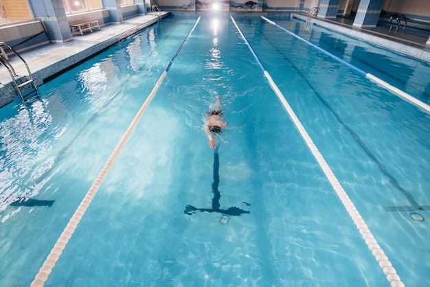 Um jovem atleta treina e se prepara para competições de natação na piscina. Estilo de vida saudável.