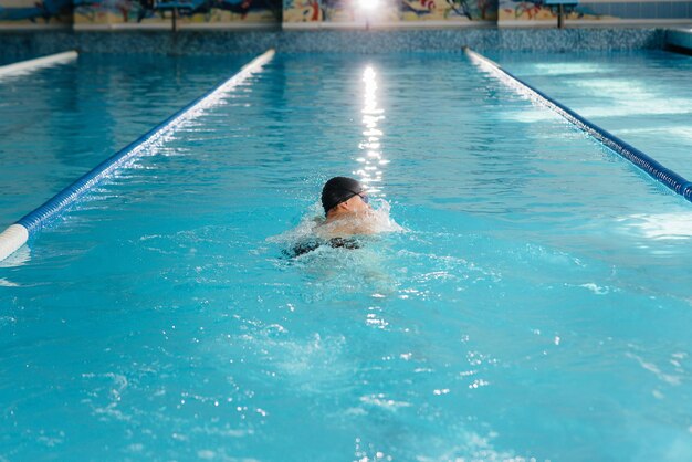 Um jovem atleta treina e se prepara para competições de natação na piscina. Estilo de vida saudável.