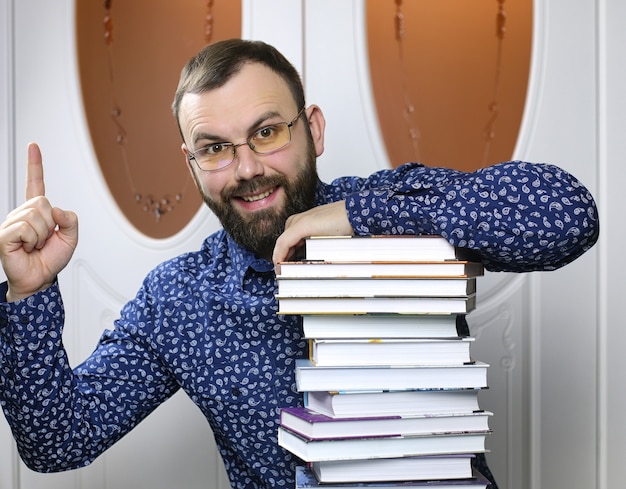 Um jovem barbudo com livros didáticos para estudar