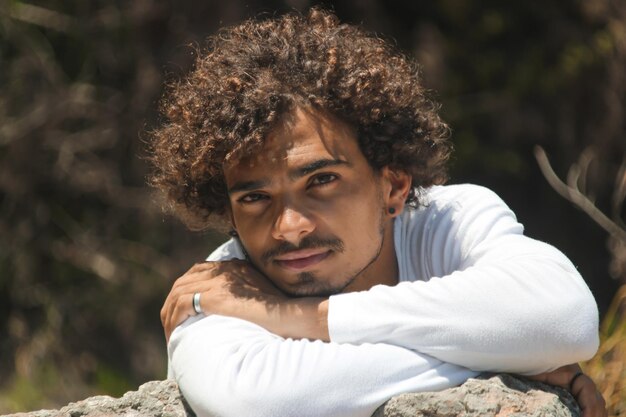 Um jovem bonito de cabelos encaracolados em uma ilha paradisíaca