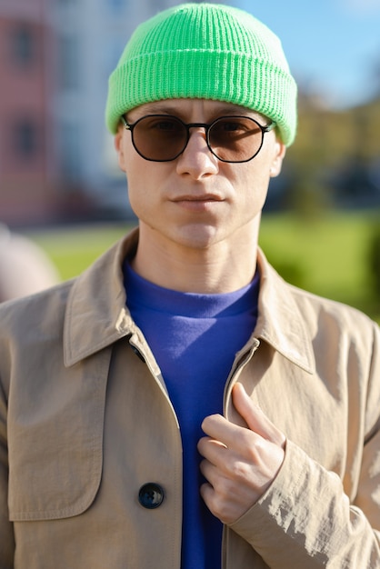 Um jovem bonito em roupas comuns, usando um chapéu e óculos