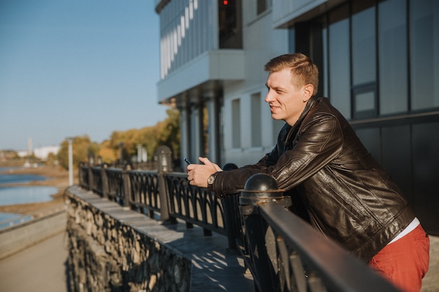 Um jovem bonito está esperando por uma reunião e sorrindo