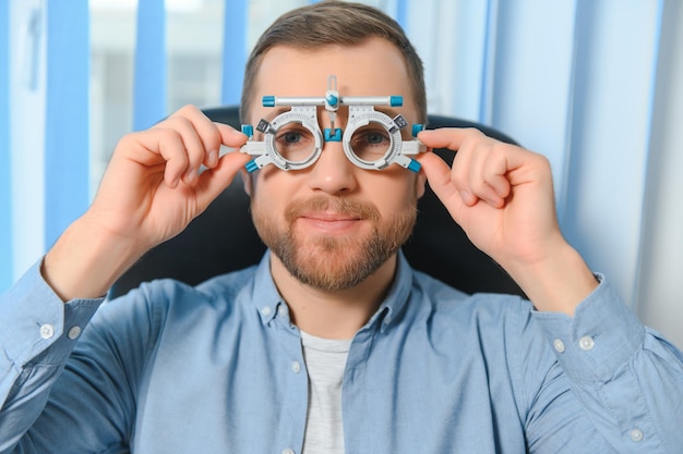 Um jovem bonito está verificando a visão ocular na clínica de oftalmologia moderna Paciente na clínica de oftalmologia