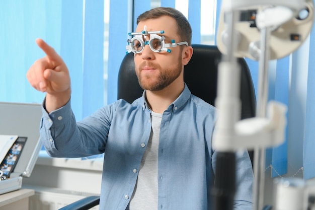 Foto um jovem bonito está verificando a visão ocular na clínica de oftalmologia moderna paciente na clínica de oftalmologia