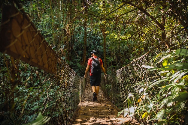 Um jovem caminhando por uma bela ponte de madeira no Cerro Azul Meambar
