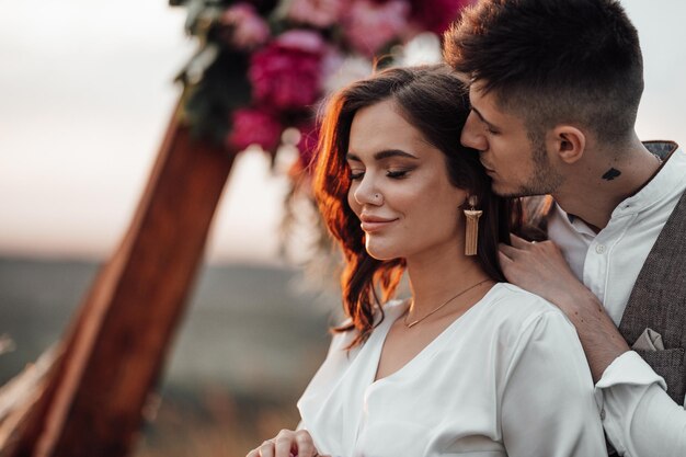 Foto um jovem casal a beijar-se ao ar livre.