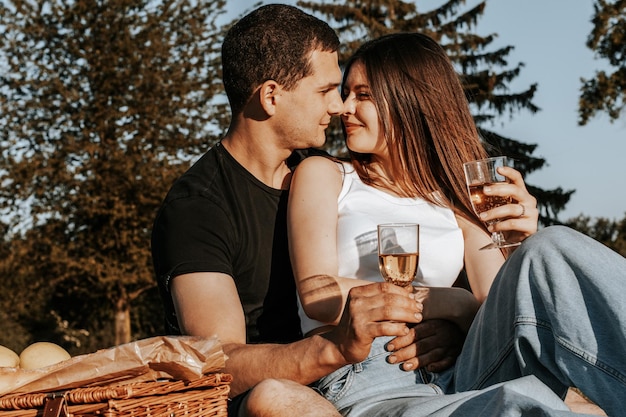 Foto um jovem casal a fazer um piquenique no parque.