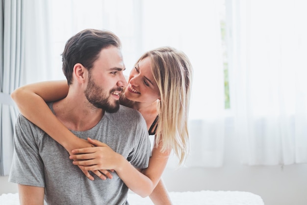 Um jovem casal a namorar no quarto de casa.