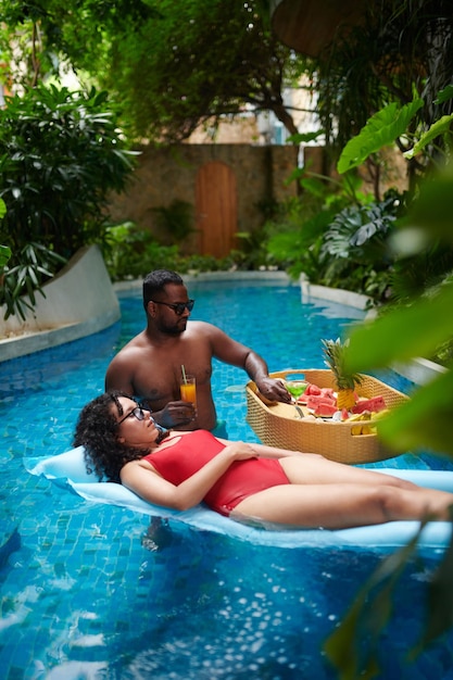 Um jovem casal a relaxar na piscina.