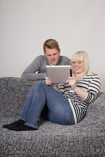 Um jovem casal a usar um tablet.