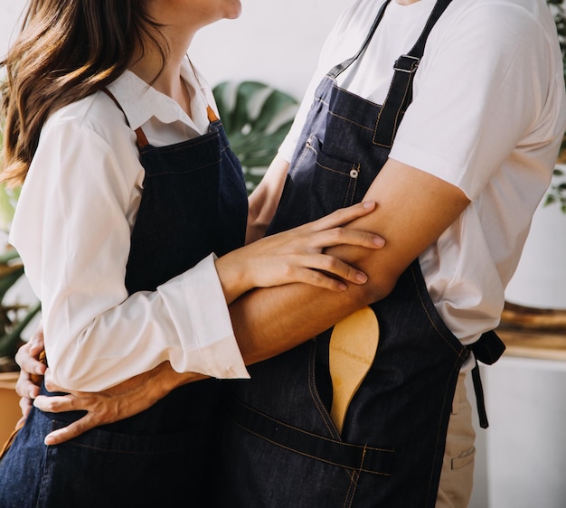 Um jovem casal adulto feliz fazendo o café da manhã e bebendo café juntos na cozinha aconchegante da casa pela manhã em casa preparando refeições e sorrindo conceito de estilo de vida, lazer e amor