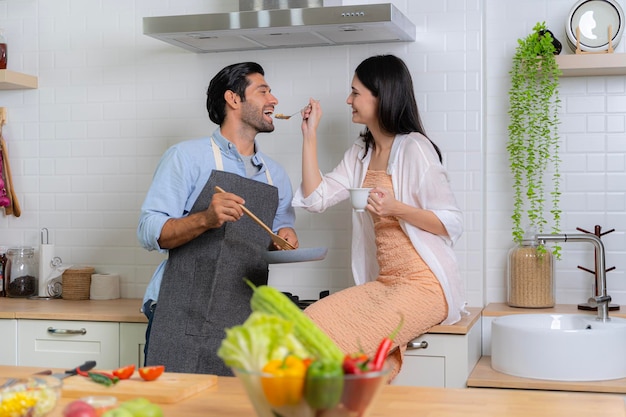 Um jovem casal apaixonado se divertindo enquanto preparava um café da manhã juntos em uma bela manhã A mulher alimentando o homem