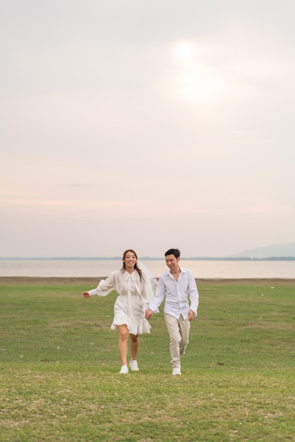 Foto um jovem casal asiático feliz com roupas de noiva e noivo.