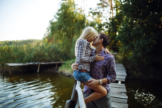 Foto um jovem casal beija no parque ao nascer do sol