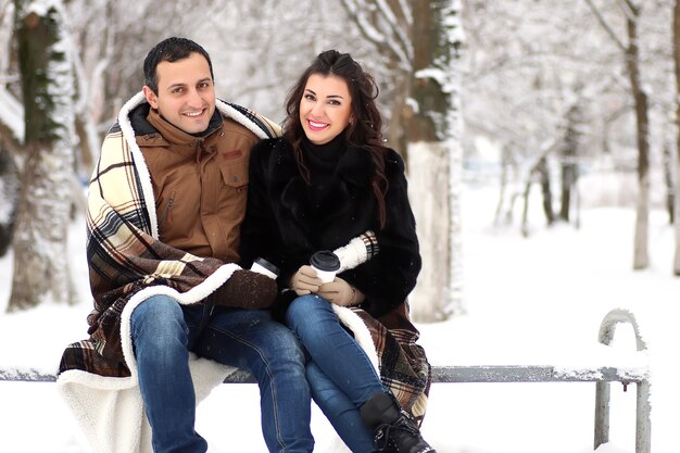 Um jovem casal caminha em um parque de inverno ao ar livre