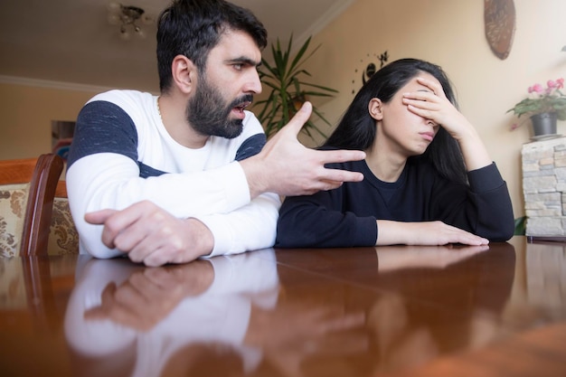 Um jovem casal chateado em casa.