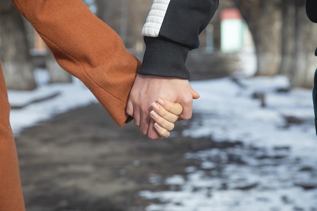 Um jovem casal de mãos dadas ao ar livre