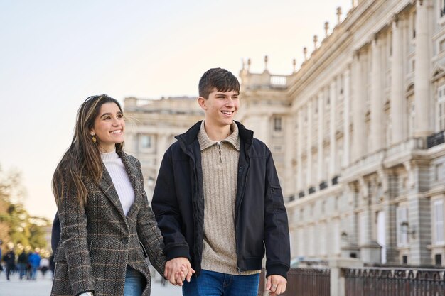 Um jovem casal de mãos dadas visitando os lugares famosos de Madrid um casal apaixonado em uma viagem