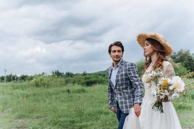 Um jovem casal de noivas se divertir e caminhar no campo ao ar livre