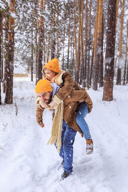 Um jovem casal de pé sob uma árvore coberta de neve