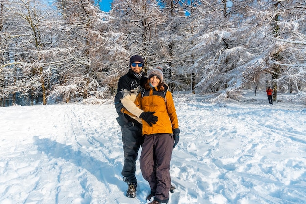 Um jovem casal desfrutando na floresta de neve no mês de janeiro no parque natural Artikutza em Oiartzun perto de San Sebastian Gipuzkoa País Basco Espanha