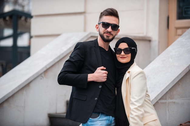 Um jovem casal elegante muçulmano feliz posando do lado de fora