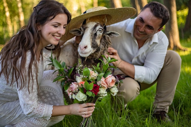 Um jovem casal em vestidos de noiva abraça um casamento rústico de carneiro