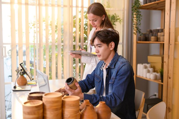 Um jovem casal empresário verificando e embalando produtos artesanais que vendem para clientes em sua loja