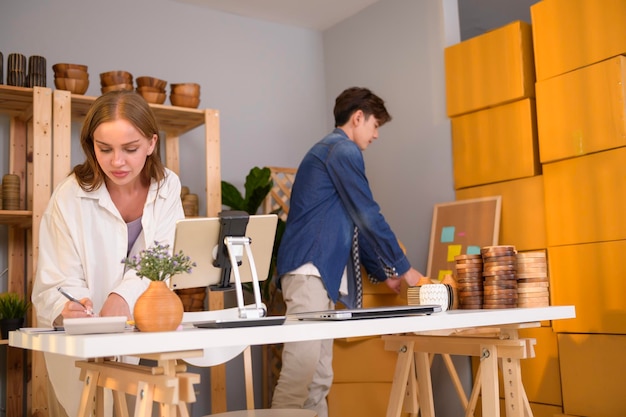 Um jovem casal empresário verificando e embalando produtos artesanais que vendem para clientes em sua loja