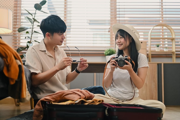 Um jovem casal encantador a preparar roupas a preparar-se para uma viagem de lua-de-mel.