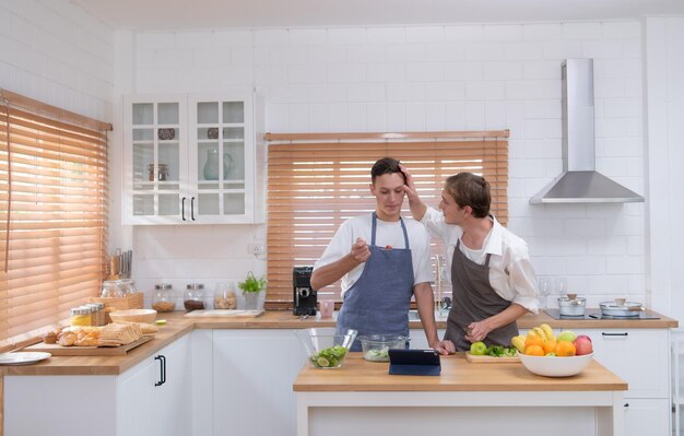 Um jovem casal entra na cozinha para preparar o jantar para celebrar o aniversário