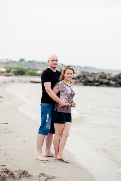 Um jovem casal está caminhando no mar