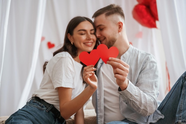 Um jovem casal está juntos em casa.