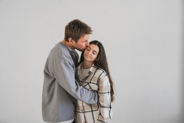 Um jovem casal está perto um do outro em um abraço expressando afeição e conforto