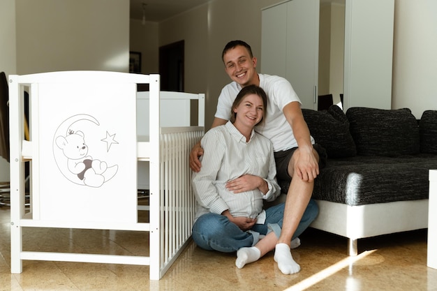 Um jovem casal feliz em sua nova casa Uma mulher grávida e seu marido estão sentados perto do