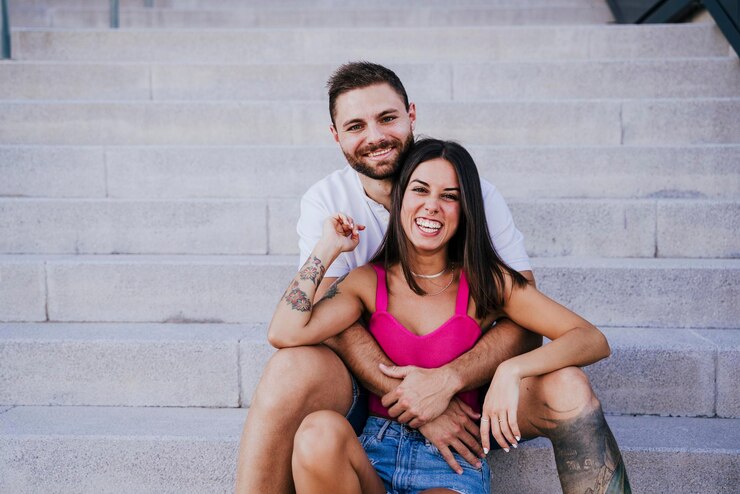 Foto um jovem casal feliz sentado na escada.